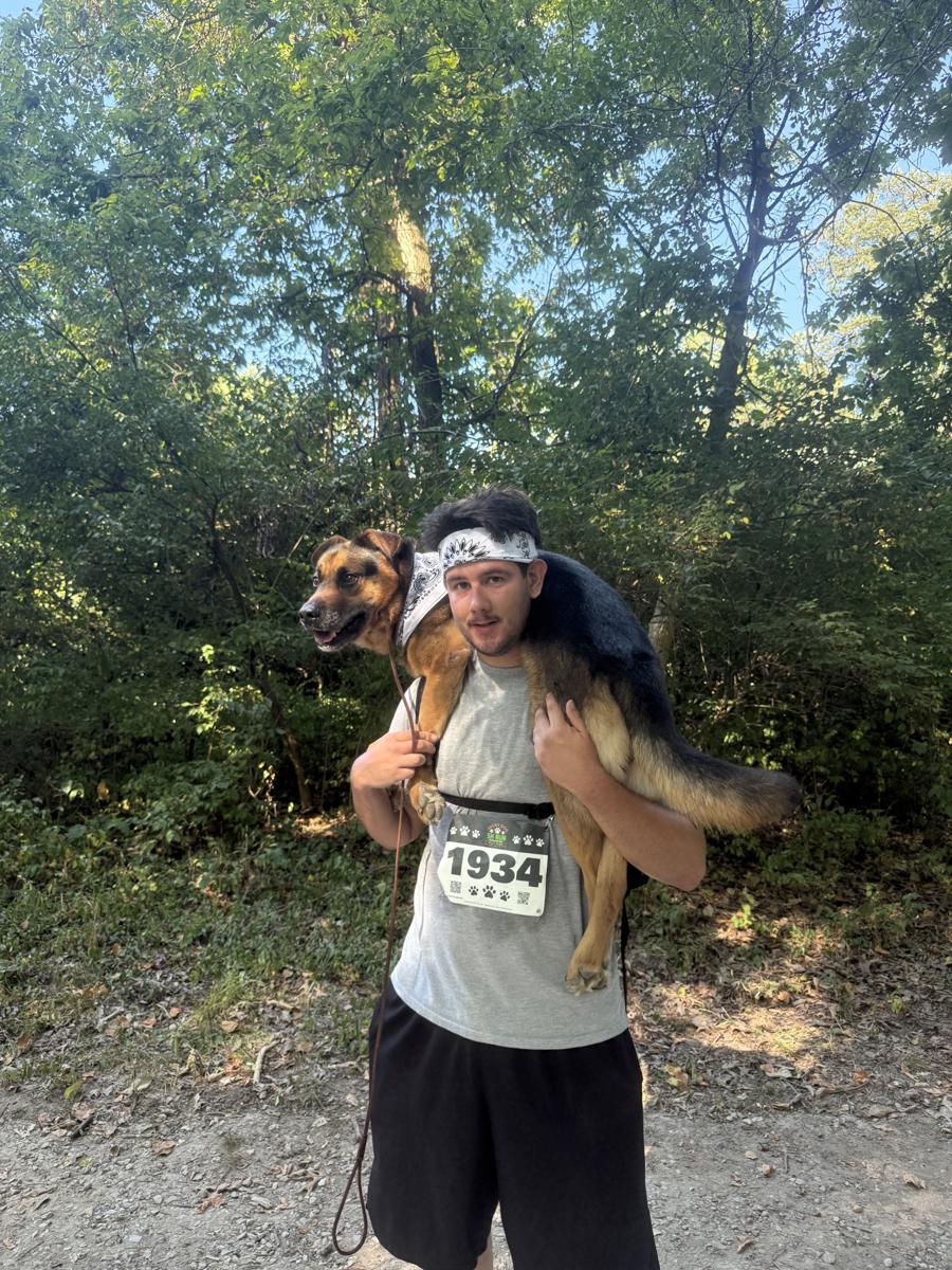 Madalyn’s husband carrying their dog across his shoulders during a 5K